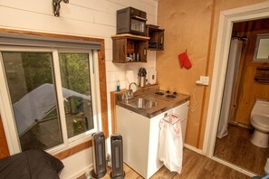 A compact kitchen with a window, a sink, a stove, and a small refrigerator. - Cozy Modern Tiny Retreat with Stargazing & Yoga Dome Access Near Yosemite Tioga Pass, Groveland, California (Groveland)