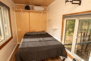 A bedroom with a bed, a window, and a shelf with items. - Cozy Modern Tiny Retreat with Stargazing & Yoga Dome Access Near Yosemite Tioga Pass, Groveland, California (Groveland)