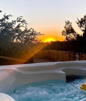 Ett område med ett bubbelbad, med en solnedgång i bakgrunden.