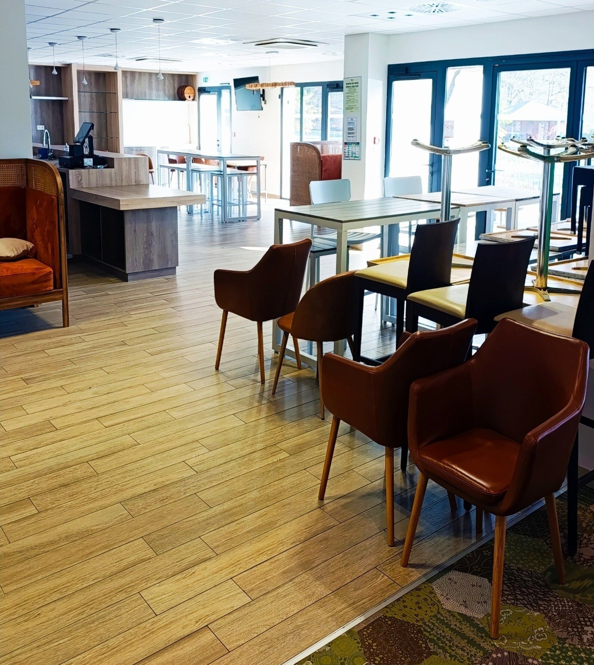 Un espace intérieur vaste et lumineux, doté d’un plancher en bois, de plusieurs coins salon et de grandes fenêtres qui laissent entrer la lumière naturelle.