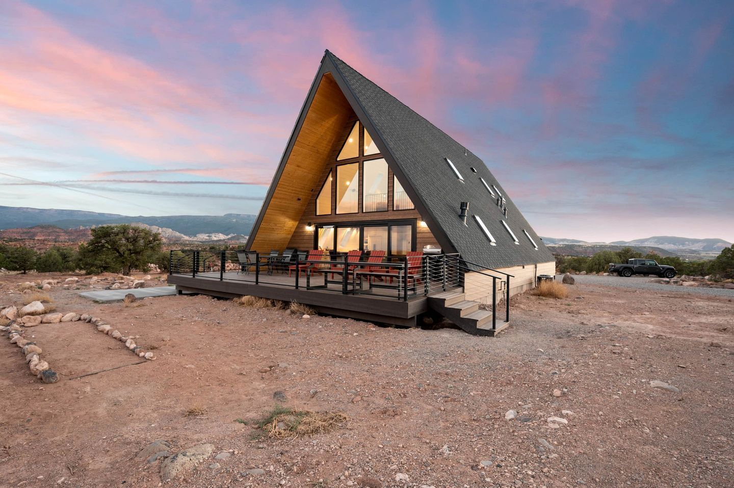 Un edificio moderno dalla forma triangolare, con ampie finestre e una terrazza con posti a sedere.