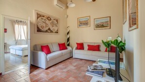 A living room with two sofas, a bed, and a dining table. - Apartments Florence - Canto dei Nelli (Firenze)
