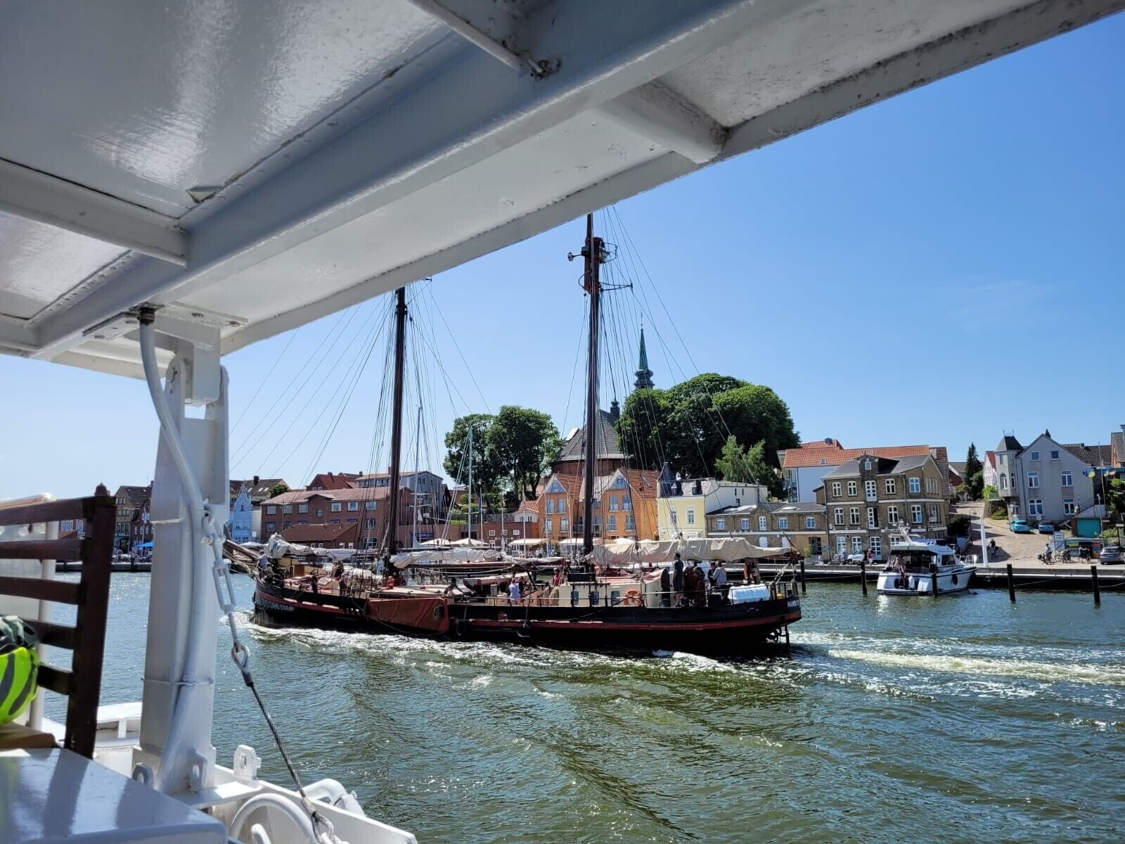 A boat docked at a pier with a town in the background.
