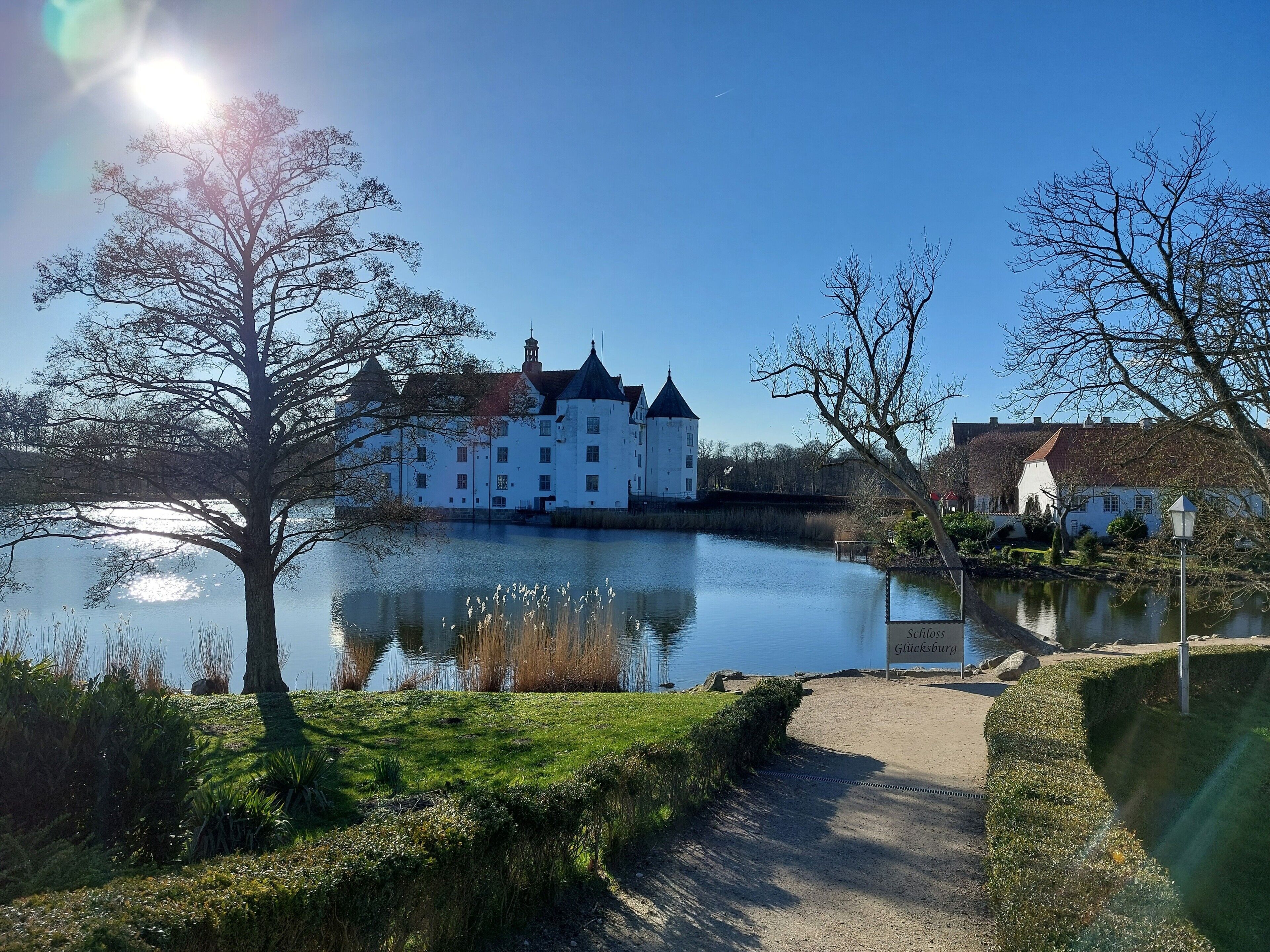 A castle by a calm lake with a clear sky.