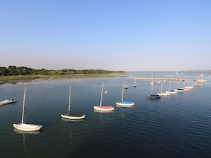 A marina with multiple sailboats docked in calm waters. - 50 Sea Road (Lymington)