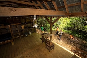 Eine rustikale Holzhütte mit einer Holzdiele, einem Tisch und einer Feuerstelle.