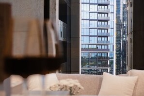 A modern living room with a large window overlooking a high-rise building. - Southbank Urban Haven! (Southbank)