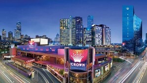Eine Stadtsicht mit einem markanten Gebäude, das eine 'CROWN'-Beschilderung trägt.