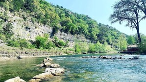 Ein Fluss mit klarem Wasser, Felsen und einem Baum auf der rechten Seite.