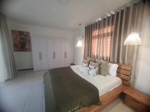 Ein Schlafzimmer mit Bett, Vorhängen, einem Kleiderschrank und einem Bild an der Wand.