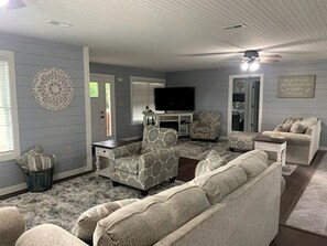 A living room with a sofa, armchairs, a coffee table, a TV, and a fireplace. - Charming Vacation Rental near Owensville, Missouri - Ideal for a Glamping Retreat with Family and Friends (Boulware Township)