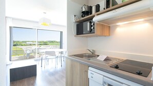 Una cocina moderna con lavavajillas integrado, un lavamanos de acero inoxidable y vistas al exterior.