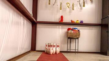 Une salle de bowling avec un tapis rouge, une rangée de quilles et une banderole sur laquelle est inscrit le mot « MARITIME ».