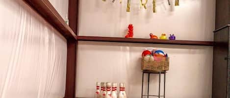 A bowling alley with a red carpet, a row of bowling pins, and a banner with the word 'MARITIME' on the wall.