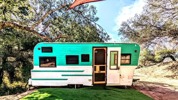 A green and white RV parked in a grassy area with trees in the background. - Sunshine Retreat- VCT#2 Glamping in Santa Ysabel, CA (Santa Ysabel)