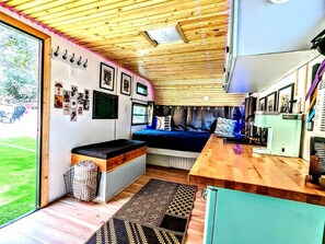 Un espace de vie compact comprenant un lit, une kitchenette et un petit coin salon.