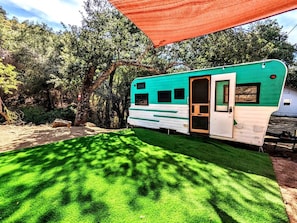 Una casa móvil con puerta, ventanas y un porche cubierto.