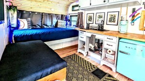A compact RV interior with a bed, kitchenette, and storage cabinets. - Sunshine Retreat- VCT#2 Glamping in Santa Ysabel, CA (Santa Ysabel)