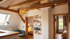 A cozy room with a wooden ceiling, a bookshelf, a bed, and a window. - Idyllic country house between Hamburg and Berlin (Langen Jarchow)