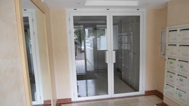 A hallway with a glass door leading to a room, a tiled floor, and a wall-mounted mailbox. - 🌿Cosy studio with 4 bedrooms and private terrace not overlooked 10min from beaches (Anglet)