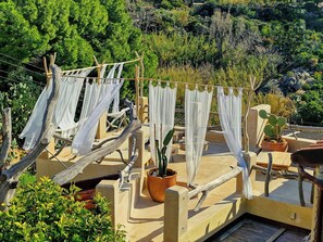 A rooftop with a clothesline, potted plants, and a view of the surrounding greenery. - Vintage house with terrace on the Elba Island (Seccheto)