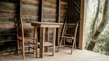 Een rustieke houten tafel en twee stoelen in een kamer met houten wanden en een houten vloer.