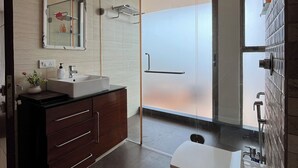 A modern bathroom with a vanity, mirror, shower, and ceiling fan.