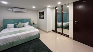 A bedroom with a bed, a nightstand, a mirror, and a wardrobe.