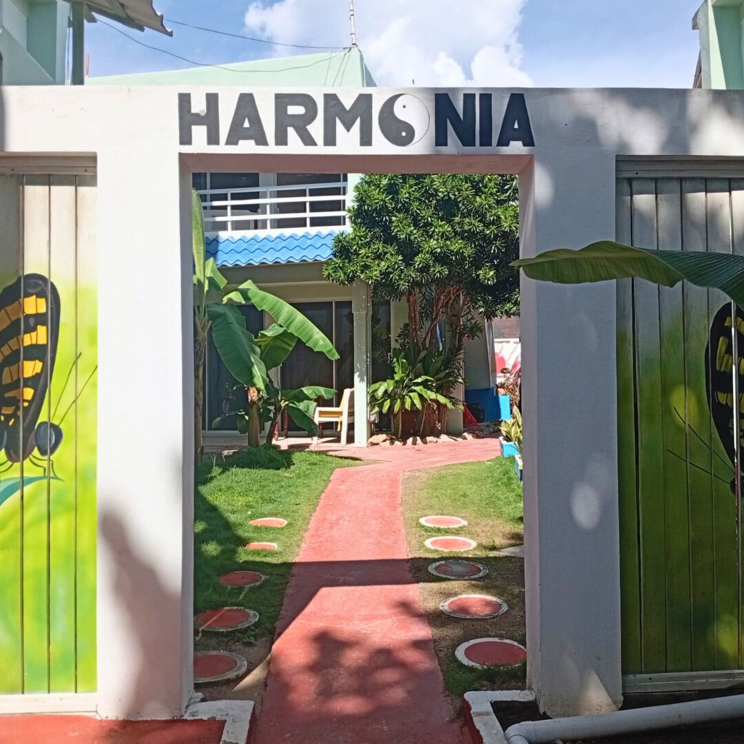 Entrada de un edificio con un letrero que dice 'HARM'S NIA'.