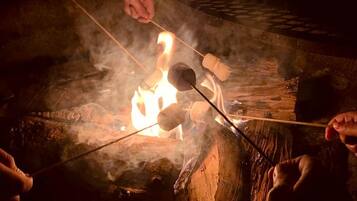 A campfire with marshmallows being roasted.