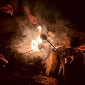 A campfire with marshmallows being roasted.