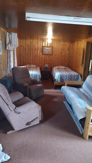 A room with two beds, a sofa, a chair, a lamp, and a framed picture on the wall. - Glamping Retreat in Bellvue, Colorado, Perfect for a Weekend Escape from Denver (Bellvue)