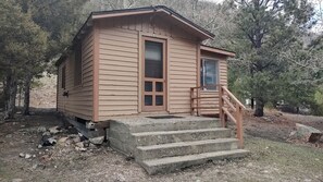A small wooden cabin with a front door, a window, and a set of concrete steps leading up to a porch. - Glamping Retreat in Bellvue, Colorado, Perfect for a Weekend Escape from Denver (Bellvue)