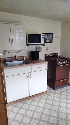 A compact kitchen with a sink, cabinets, a microwave, and a stove. - Glamping Retreat in Bellvue, Colorado, Perfect for a Weekend Escape from Denver (Bellvue)