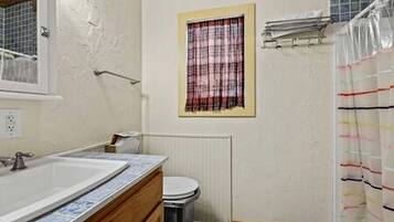 Ein Badezimmer mit Waschbecken, Toilette und Duschvorhang.