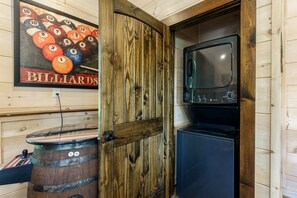 Une pièce décorée sur le thème du billard, avec une porte en bois, une table de billard et un four à micro-ondes encastré.