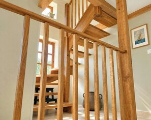Una escalera de madera con vistas a un comedor y una olla rústica.