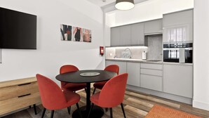 Una cocina moderna con armarios grises, una encimera negra y un horno empotrado.