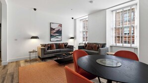 Una sala de estar moderna con sofá, mesa de centro y comedor.