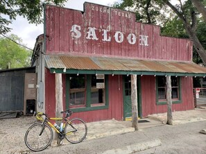 A rustic building with a red facade and a sign that reads 'ZUEHL TEXAS SALOON.' - #18Son’s Rio Cibolo Deluxe Safari Cabin (Cibolo)