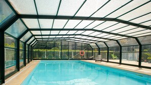 An indoor swimming pool with a glass enclosure, a lifebuoy, and lounge chairs. - 6-guest Stay With Wellness Area (Dinan)