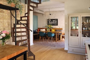 A dining area with a wooden table, chairs, a bench, and a staircase. - Idyllic hideaway in the countryside (Marienwerder)
