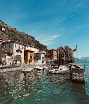 A waterfront property with buildings, a dock, and boats. - Mansarda Spadone Attic (Musso)
