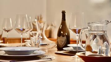 A dining table set with wine glasses, a bottle, and a pitcher.