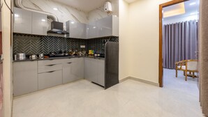 Una cocina moderna con armarios grises, una campana extractora negra y un salpicadero con patrón de espiga.