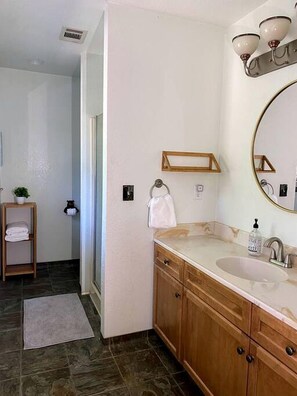 A bathroom with a wooden vanity, a sink, a mirror, and a towel rack. - Mountain Family Cottage Ideal for Outdoor Adventures in Ohio (Wishon)