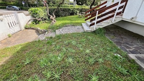 A residential area with a paved driveway, a wooden fence, and a stone staircase leading to a house. - Apartment 'Bilocale con Giardino Privato' with Exclusive Garden (Marina di Bibbona)