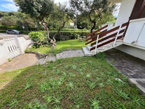 Ein Wohngebiet mit befestigter Auffahrt, Holzzaun und Steintreppe, die zu einem Haus führt.
