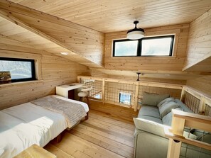 A cabin with a loft bedroom, a dining area, and a seating area. - Luxurious Glamping Tree House at Starved Rock, Perfect for a Weekend Escape from Chicago (Ottawa)