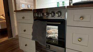 Une cuisine équipée d’un four encastré, d’un plan de travail en bois et d’une serviette accrochée à la porte du four.